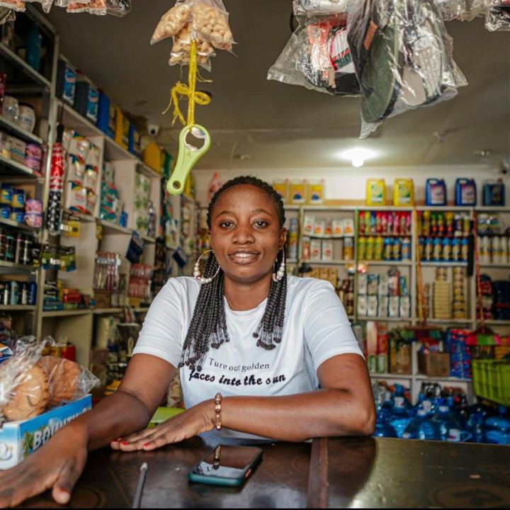 Une commerçante derrière le comptoir de sa boutique